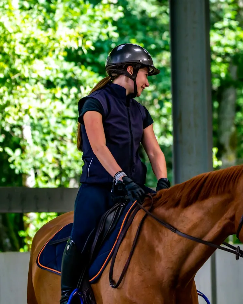 A young rider in a helmet on a chestnut horse